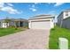 One-story house with gray garage door and landscaped lawn at 1833 Ross Hammock Ave, Groveland, FL 34736