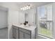 Double vanity bathroom with gray cabinets and a window at 1833 Ross Hammock Ave, Groveland, FL 34736