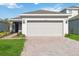 One-story house with gray garage door and landscaped lawn at 1833 Ross Hammock Ave, Groveland, FL 34736