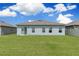 House back view, showcasing a spacious lawn and sliding glass door at 162 Piave St, Haines City, FL 33844
