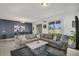 Spacious living room with L-shaped sofa, coffee table, and large windows at 15259 Willow Arbor Cir, Orlando, FL 32824
