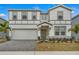 Two story home with gray and white siding, gray roof, and a two car garage at 2210 Lelani Cir, Davenport, FL 33897