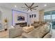 Living room with a gray sectional sofa, a fireplace and large TV at 2210 Lelani Cir, Davenport, FL 33897