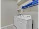 Bright laundry room with washer, dryer and shelving at 2210 Lelani Cir, Davenport, FL 33897