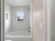 Bathroom with a bathtub, marble tile and window at 18645 Seaview St, Orlando, FL 32833