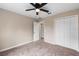 Bright bedroom featuring a ceiling fan, carpet, and double-door closet at 18645 Seaview St, Orlando, FL 32833