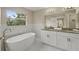 Elegant bathroom with double vanity, soaking tub, and marble tile at 18645 Seaview St, Orlando, FL 32833