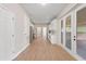Long hallway with light wood floors and white doors leading to kitchen and other rooms at 18645 Seaview St, Orlando, FL 32833