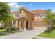 Two-story house with tan exterior, tile roof, and a two car garage at 290 Las Fuentes Dr, Kissimmee, FL 34746