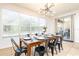 Bright dining area with large windows, a farmhouse table, and black metal chairs at 290 Las Fuentes Dr, Kissimmee, FL 34746