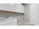 Laundry room with white cabinets and countertop sink at 2153 Divot Dr, Daytona Beach, FL 32124