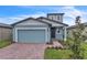 Two-story house with light blue garage door and brick driveway at 3793 Bluethread Way, Poinciana, FL 34759