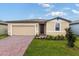 Tan house with dark brown door and brick driveway at 3170 Viceroy Ct, Poinciana, FL 34759