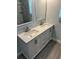 Double vanity bathroom with large mirror and shower at 2030 Cipriano Pl, The Villages, FL 32159