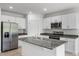 Modern kitchen with white cabinets and granite island at 3206 Viceroy Ct, Poinciana, FL 34759
