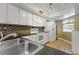 Kitchen with white cabinets, double sink, and tile backsplash at 4113 Fairview Vista Pt # 308, Orlando, FL 32804