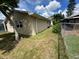 Tan house exterior with partial view of backyard and chain link fence at 2406 W Orange Blvd, Kissimmee, FL 34741