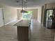 Spacious kitchen with modern island, stainless steel appliances, and light wood cabinets at 2406 W Orange Blvd, Kissimmee, FL 34741