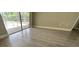 Bright bedroom featuring wood-look flooring and a large window with blinds at 2406 W Orange Blvd, Kissimmee, FL 34741