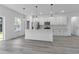 Modern kitchen with white cabinets, island, and stainless steel appliances at 526 Marion Oaks Trl, Ocala, FL 34473