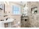 Updated bathroom with tiled shower, pedestal sink, and window at 732 Edgewater Dr, Orlando, FL 32804