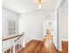 Upstairs hallway with hardwood floors, white railing, and access to bedrooms and bathroom at 732 Edgewater Dr, Orlando, FL 32804