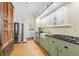 Charming kitchen featuring green cabinetry, stainless steel appliances, and a vintage pantry at 732 Edgewater Dr, Orlando, FL 32804
