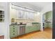 Updated kitchen with green cabinets, stainless steel appliances, and a farmhouse sink at 732 Edgewater Dr, Orlando, FL 32804