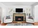 Fireplace with white tufted chairs, area rug, and hardwood floors at 732 Edgewater Dr, Orlando, FL 32804