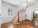 Elegant staircase with white railing and hardwood treads in a bright foyer at 732 Edgewater Dr, Orlando, FL 32804