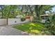 Landscaped backyard with a brick patio and a white swing at 732 Edgewater Dr, Orlando, FL 32804
