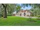 Two-story home with a tile roof, lush lawn, and mature trees at 732 Edgewater Dr, Orlando, FL 32804