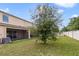 Small backyard with a tree and privacy fence at 9021 Carlotta Way, Kissimmee, FL 34747