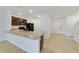 Open concept kitchen with island, stainless steel appliances and access to entryway at 9021 Carlotta Way, Kissimmee, FL 34747