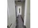 Long hallway with carpeted flooring and access to bedrooms at 1075 Trappers Trail Loop, Davenport, FL 33896
