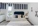 Well-lit bedroom featuring a navy blue accent wall and striped bedding at 2908 Waterlily Way, Poinciana, FL 34759