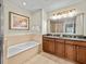 Double vanity bathroom with granite countertop and soaking tub at 7651 Whisper Way # 401, Reunion, FL 34747