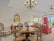 Elegant dining room with a round glass table and chandelier at 7651 Whisper Way # 401, Reunion, FL 34747