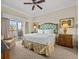 King-size bed, ensuite bathroom, and access to a private balcony at 7651 Whisper Way # 401, Reunion, FL 34747