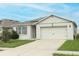 Tan house with brown accents, solar panels, and a two-car garage at 277 Ludisia Loop, Davenport, FL 33837