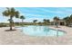 Community pool with lounge chairs and palm trees at 277 Ludisia Loop, Davenport, FL 33837