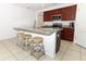 Island kitchen with granite countertops and wooden cabinets at 277 Ludisia Loop, Davenport, FL 33837