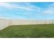 Large grassy backyard with a white vinyl fence at 277 Ludisia Loop, Davenport, FL 33837