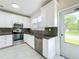 Modern kitchen with white cabinets, granite counters, and backyard access at 700 Eldridge St, Orlando, FL 32803