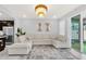 Open living room with sectional sofa, kitchen view, and access to the backyard at 2599 Nouveau Way, Kissimmee, FL 34741