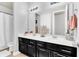 Bathroom boasts dual vanity with dark cabinetry and a large mirror at 2599 Nouveau Way, Kissimmee, FL 34741