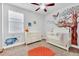 Adorable Bedroom features Winnie the Pooh wall decals, crib, dresser, and window at 2599 Nouveau Way, Kissimmee, FL 34741