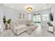 Bright living room boasts a large sectional sofa, stylish chandelier, and view of backyard at 2599 Nouveau Way, Kissimmee, FL 34741