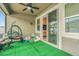 Covered patio with artificial turf, playful seating, and access to backyard at 2599 Nouveau Way, Kissimmee, FL 34741