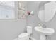 Small bathroom with pedestal sink, toilet, and framed artwork at 2599 Nouveau Way, Kissimmee, FL 34741
